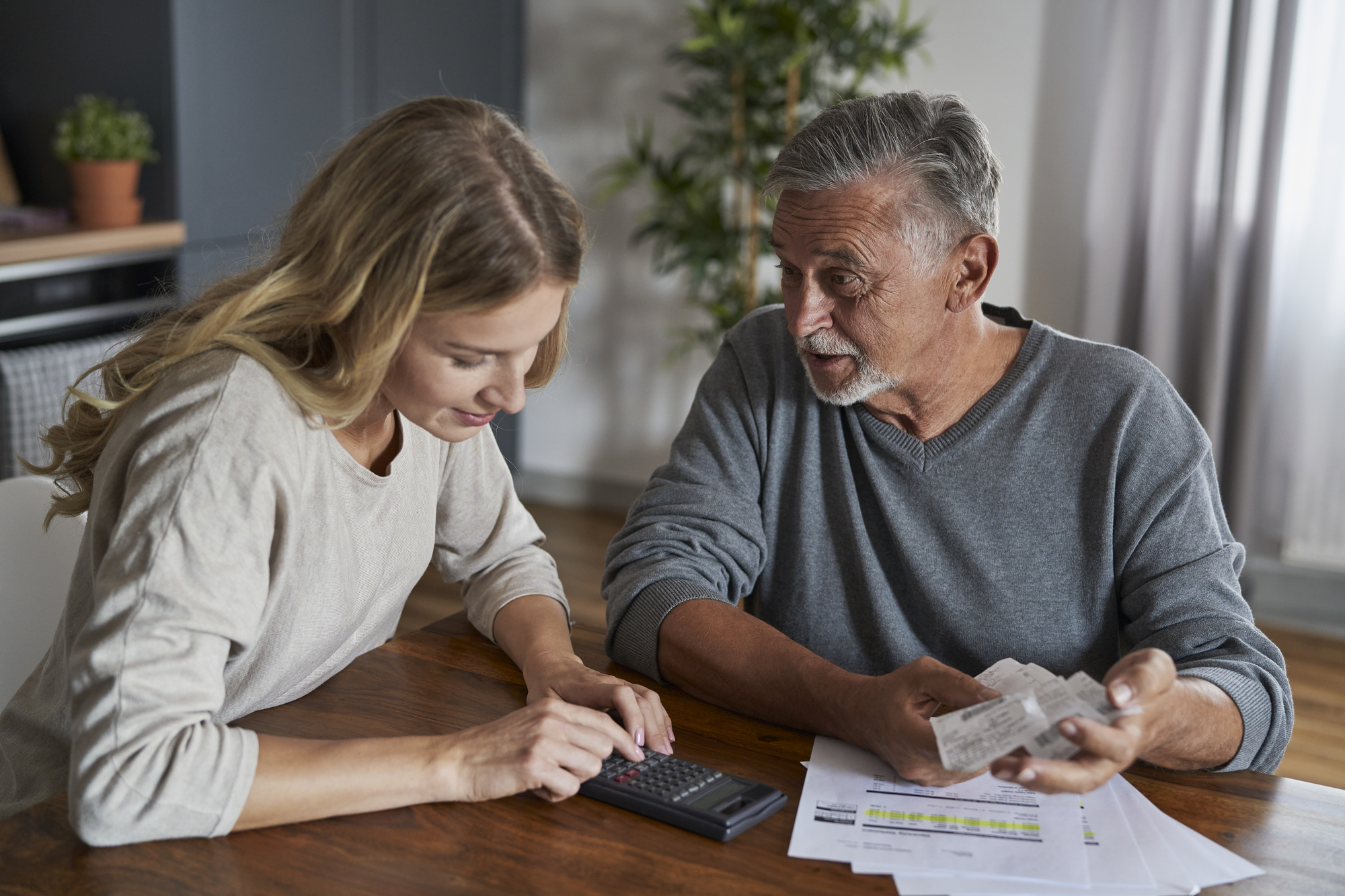 Senior man with adult daughter looking for solution in financial problem